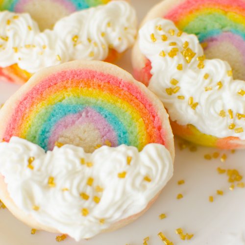 Slice ‘n Bake Rainbow Sugar Cookies are made from a soft vanilla sugar cookie dough, rolled in layers, then sliced and baked. The cookies are finished off with vanilla butter cream clouds.