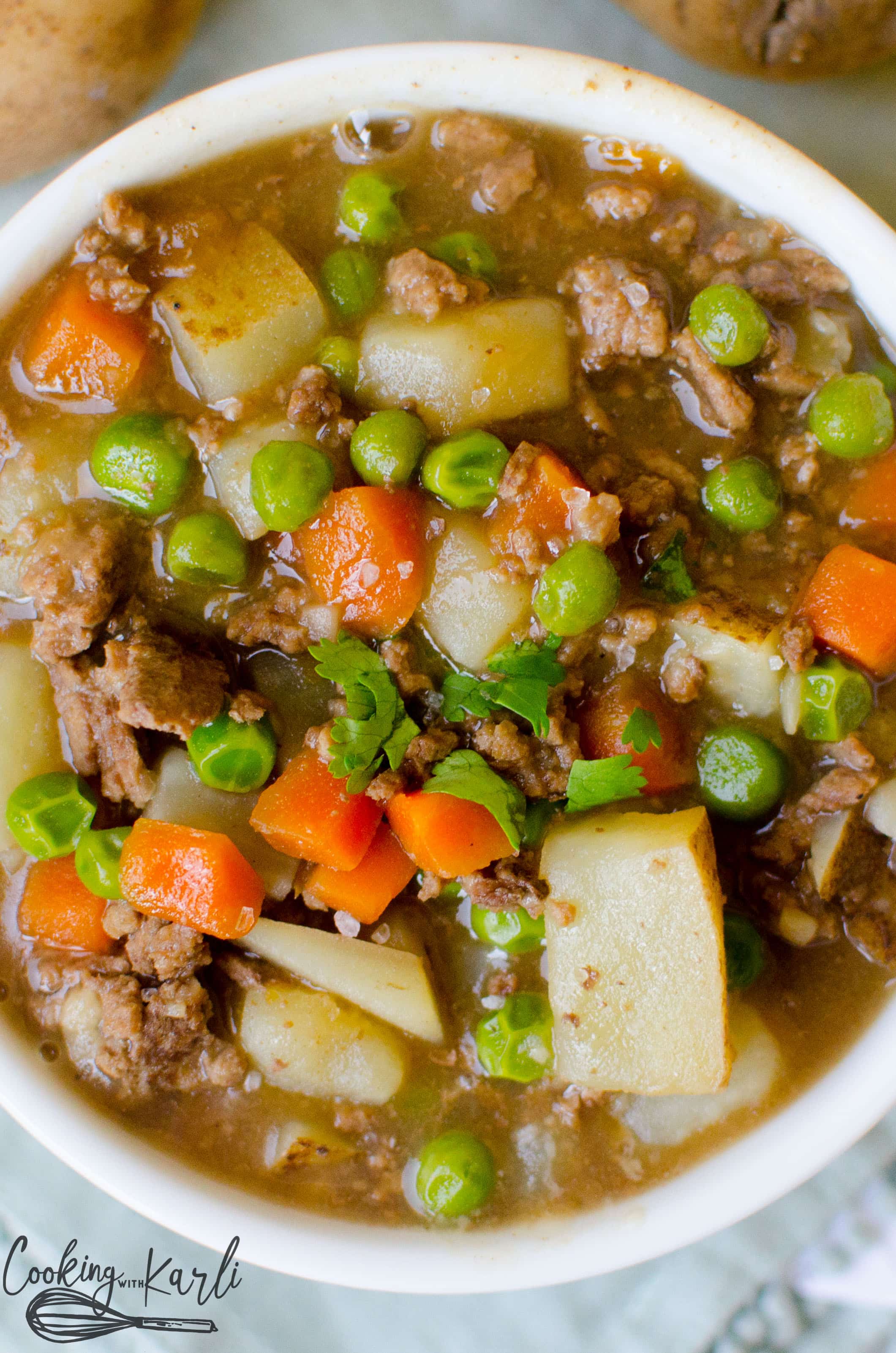 Instant Pot Ground Beef Stew made with potato chunks, carrots, peas and ground beef which are swimming in a thick delicious gravy.