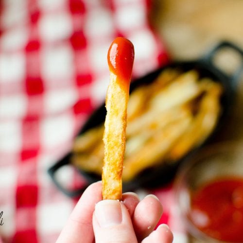 Crispy oven baked french fry dipped in ketchup