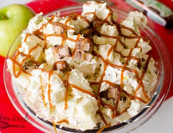 creamy salad made with cream cheese, cool whip, and brown sugar over apples and candy bars.