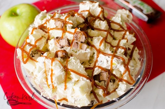 creamy salad made with cream cheese, cool whip, and brown sugar over apples and candy bars.