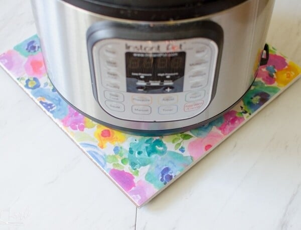 DIY hot plate made from a tile and scrapbook paper makes the perfect Instant Pot stand.