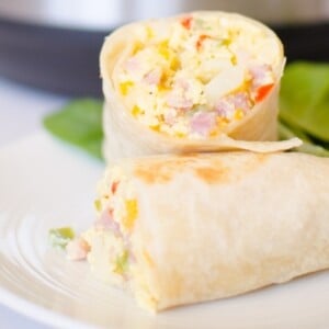 Instant Pot Breakfast Burritos are an easy way to make breakfast burritos for a crowd! Simple ingredients like frozen O'Brien Hash browns, Diced Ham, and Eggs are thrown in the Instant Pot to cook without babysitting!  |Cooking with Karli| #breakfast #Instantpot #pressurecooker #breakfastburrito #hashbrowns #eggs #recipe