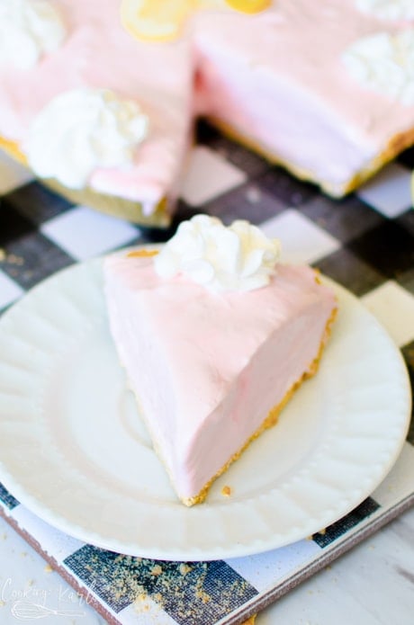 Frozen Pink Lemonade Pie served on a small plate with whipping cream on top.