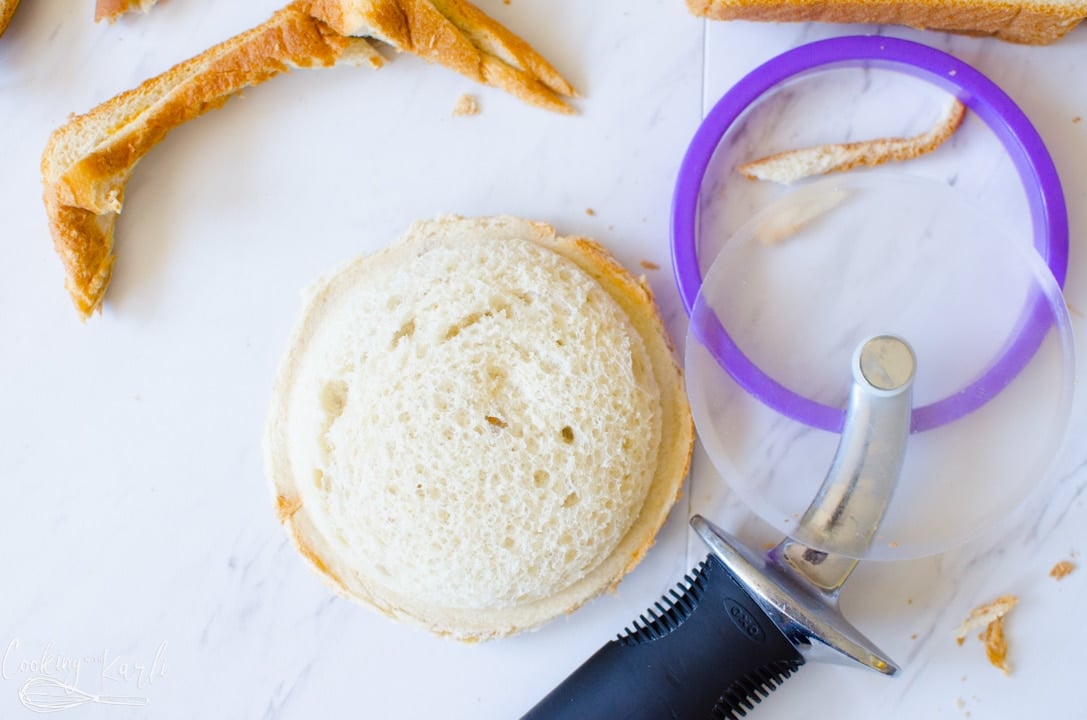 pizza cutter is used to cut the crust off of the sandwich