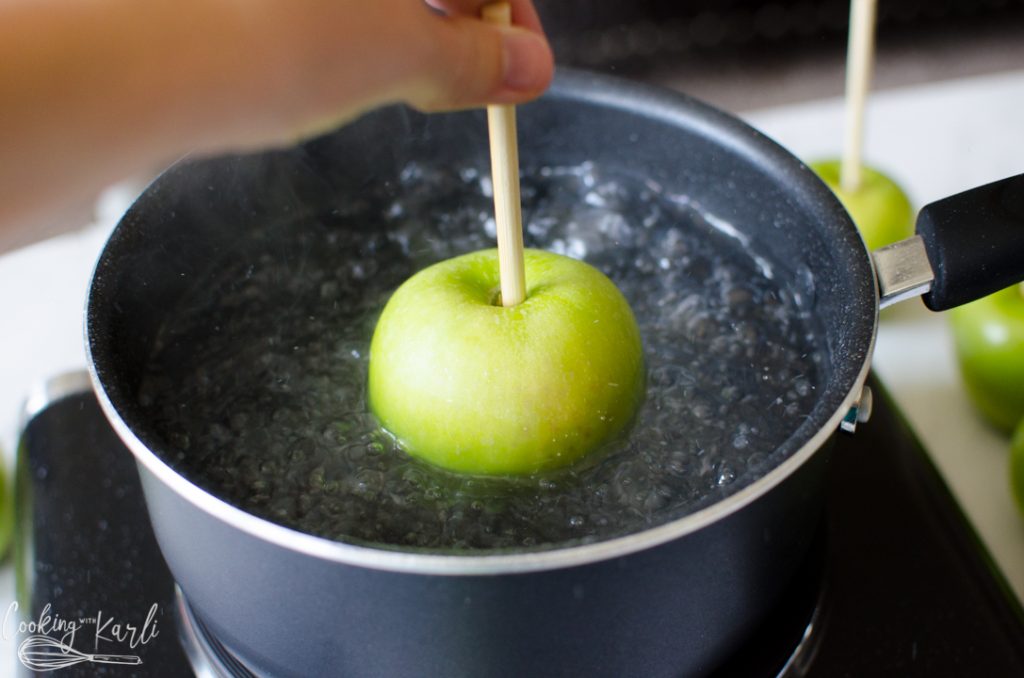 apples being dipped in boiling water