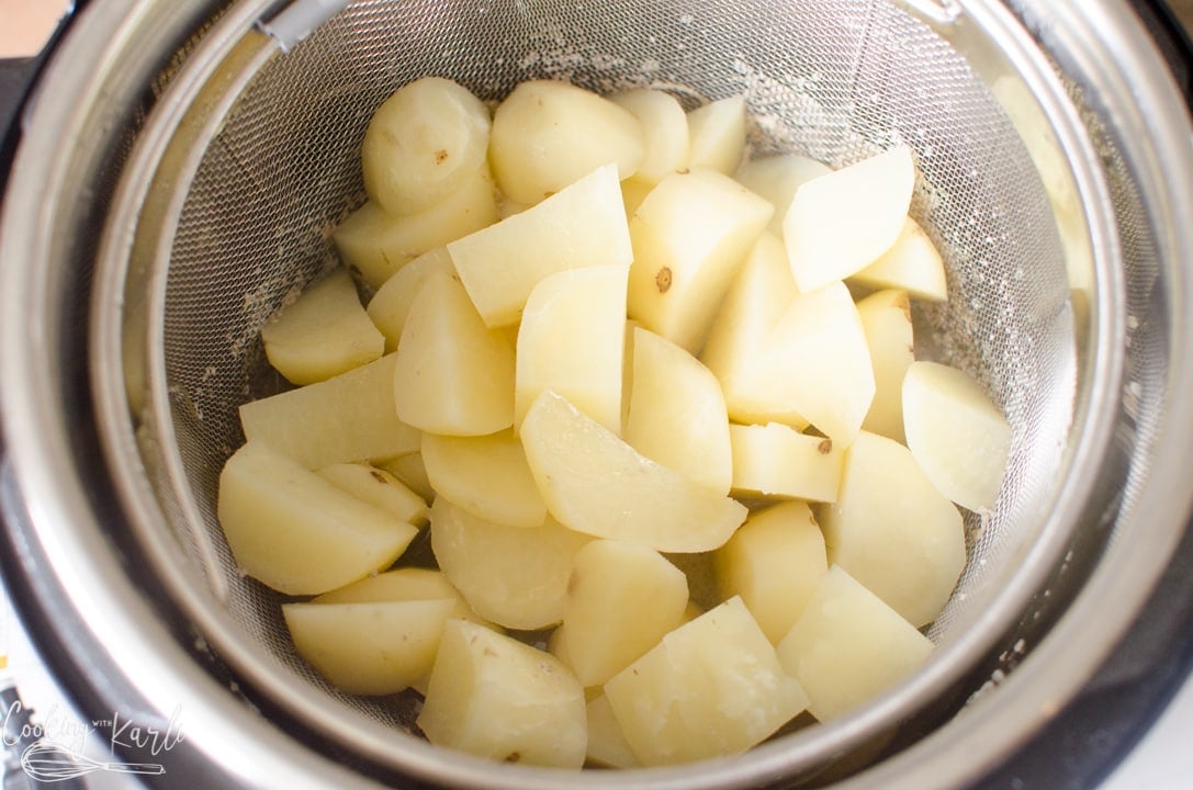 steamer basket with the potatoes in it inside of the Instant Pot.