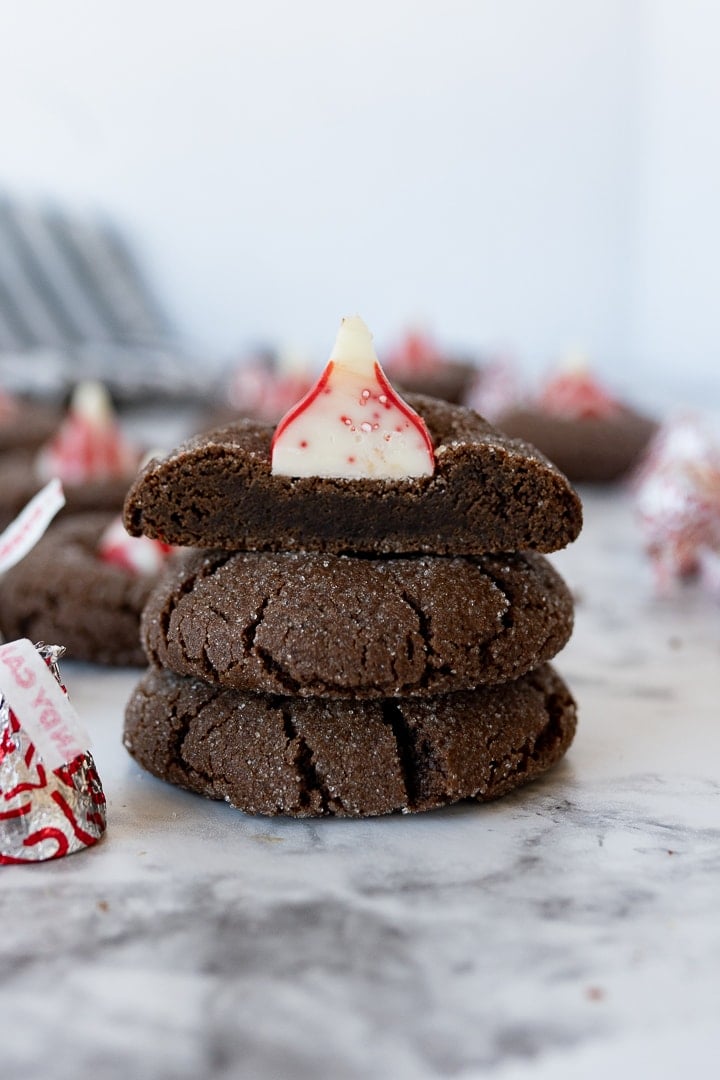 chocolate cookies with peppermint kisses in the middle, stacked on top of each other. 