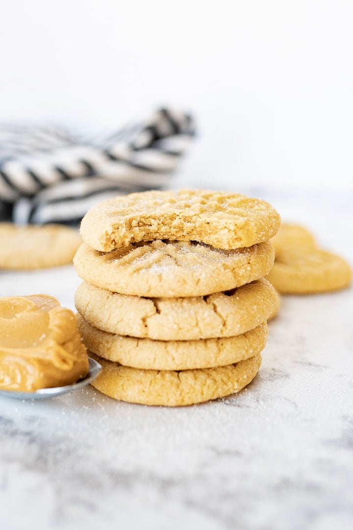 peanut butter cookies, stacked on top of each other on the counter.