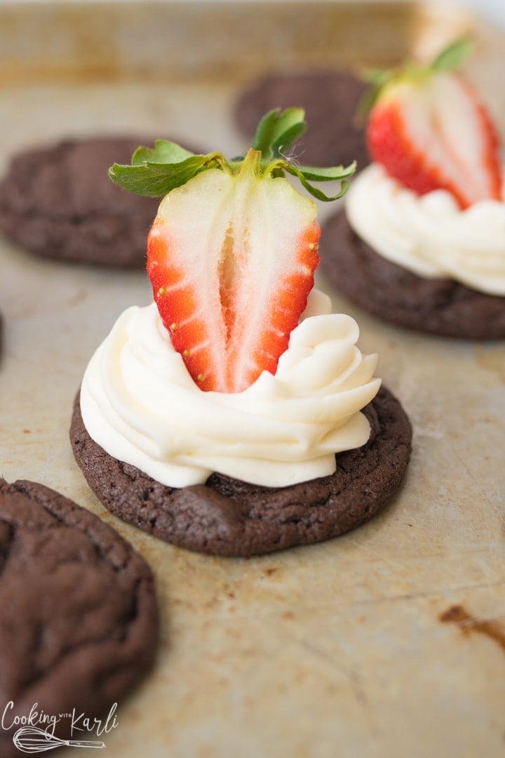 chocolate cookie with cream cheese frosting and a strawberry.