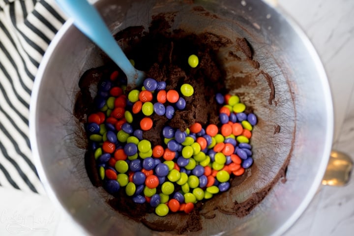 chocolate cookie dough with m&m's being mixed in