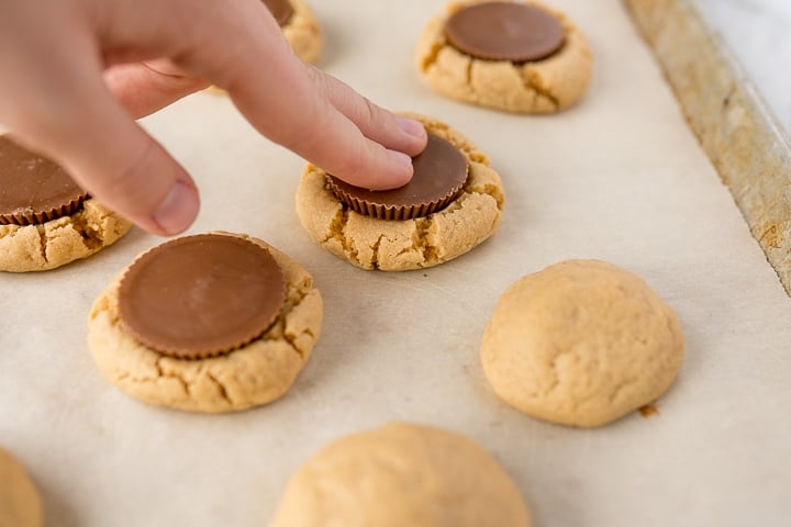 Reeses cup being pressed into the peanut butter cookie