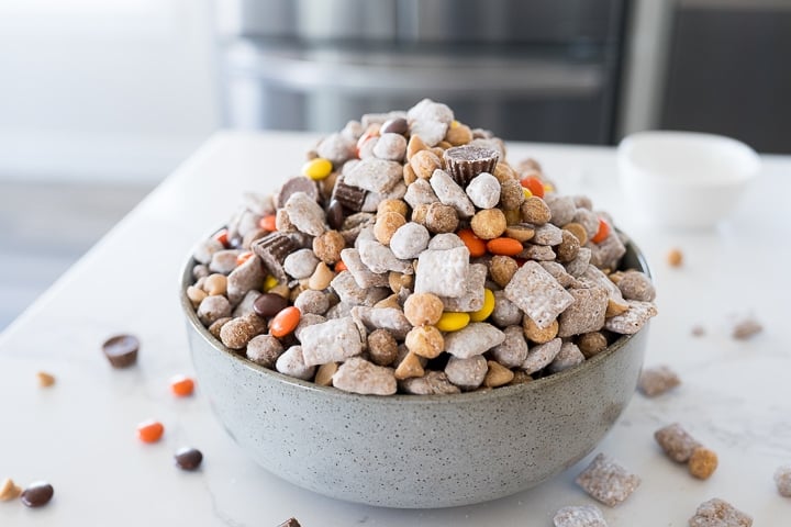 peanut butter muddy buddies, or reese's snack mix in a serving bowl