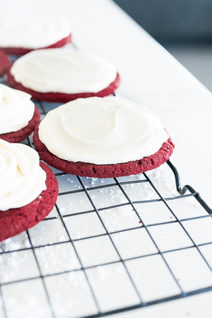 red velvet cookie on cooling rack with cream cheese frosting