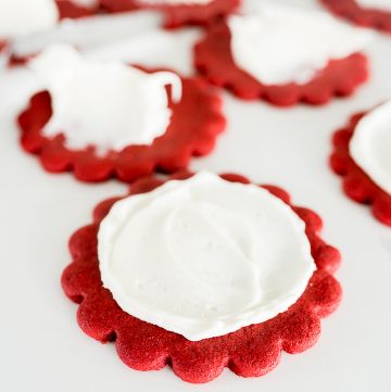 red velvet cut out cookies being frosted