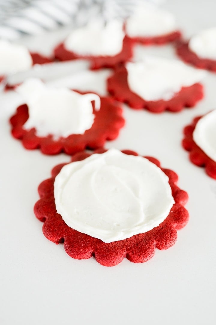 red velvet cut out cookies being frosted