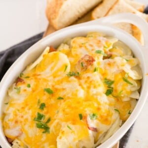 scalloped potatoes and ham in a white baking dish