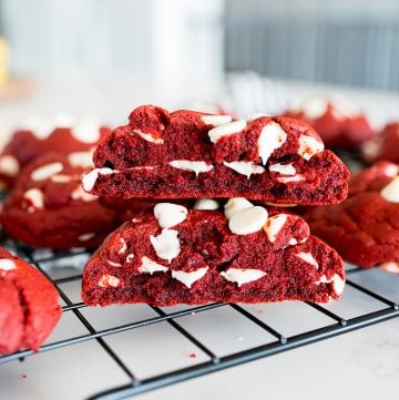 red velvet cookie with white chocolate chips, broken in half and stacked on top of each other