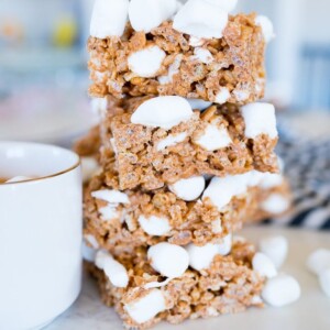 Rice Krispies that are hot chocolate flavored stacked on top of each other next to a cup of cocoa