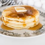 Buttermilk pancakes, stacked on a plate with syrup and butter on top