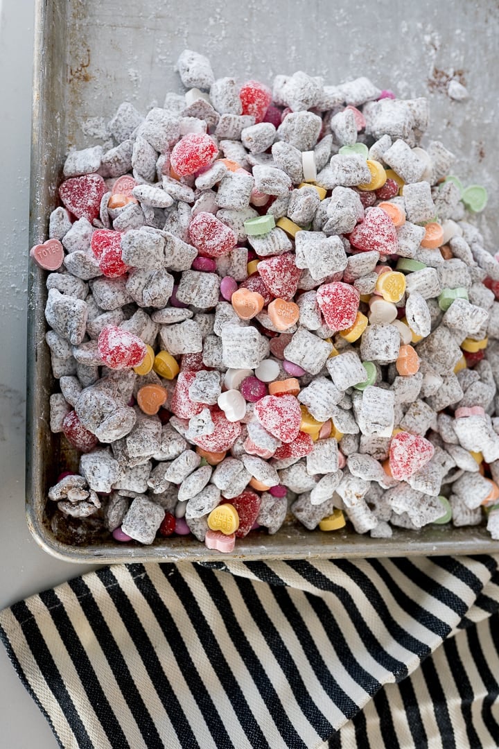 muddy buddies with valentines candies on a cookie sheet