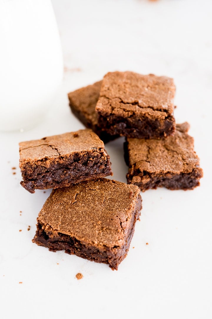 brownies made from scratch, cut and stacked by a glass of milk