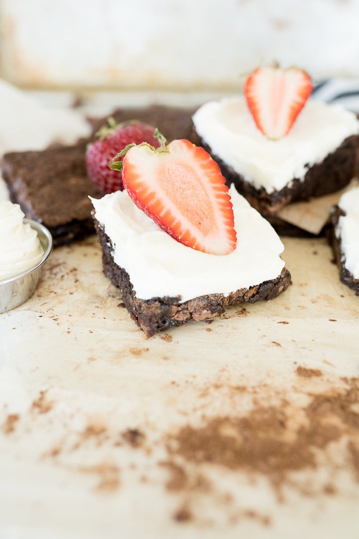 brownies with cheesecake frosting and a strawberry on top