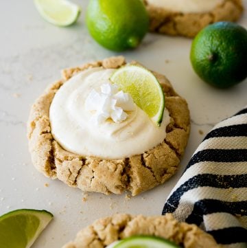 crumbl copycat key lime pie cookies with lime slices on the counter