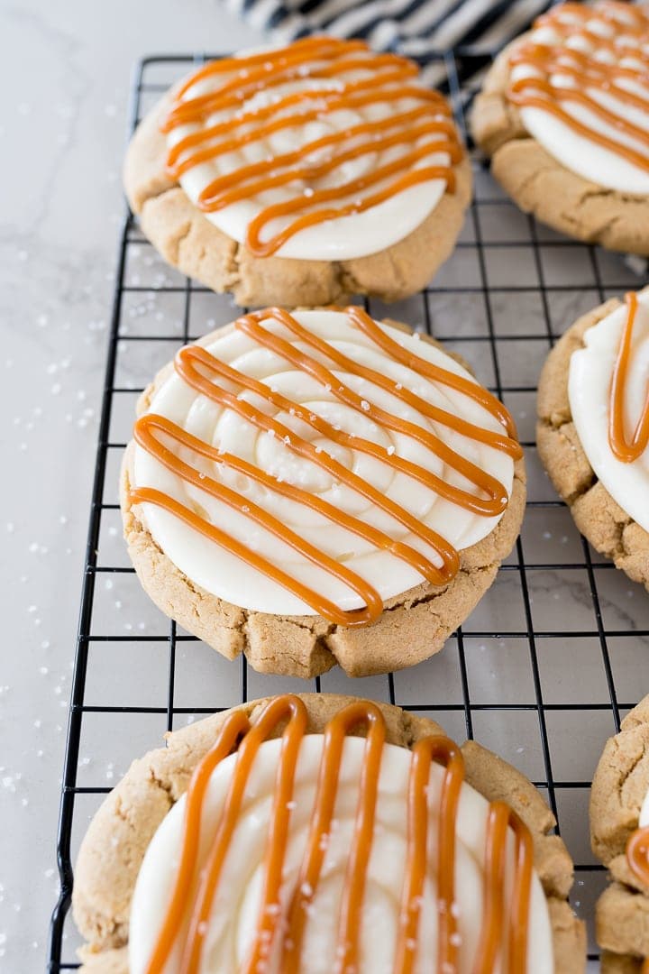 salted caramel cheesecake cookies on a black cookie cooling rack