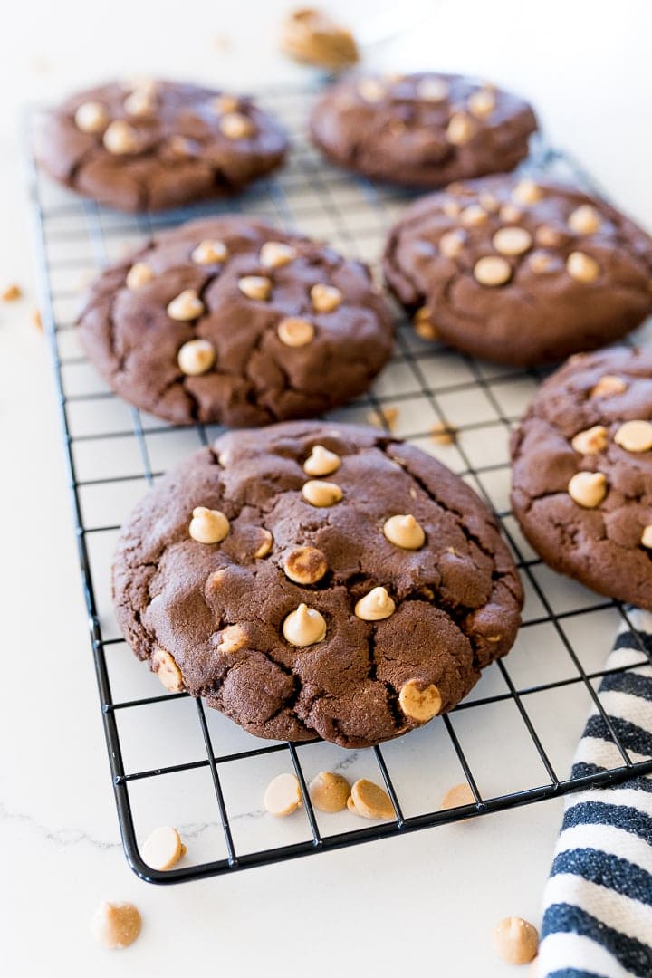chocolate cookies with peanut butter chips on a black cookie rack