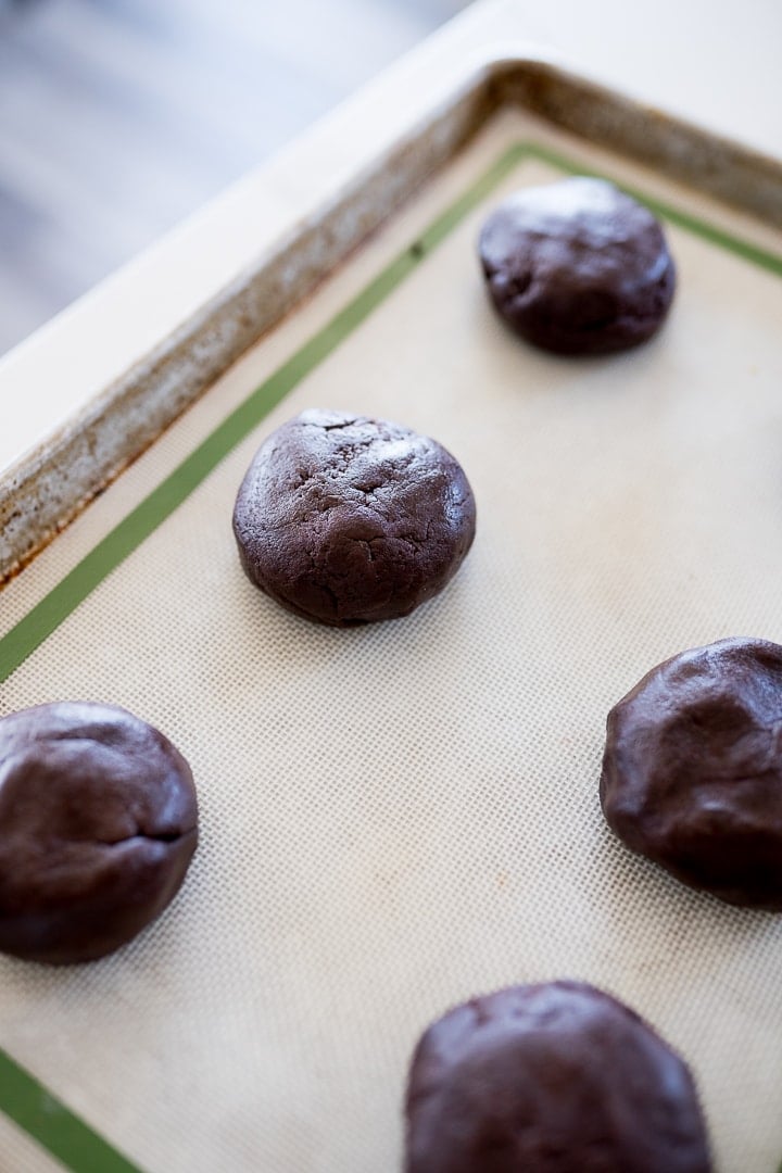 chocolate cookie dough in a ball on a baking sheet