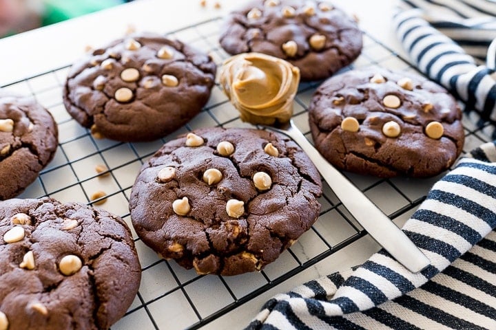chocolate cookies with peanut butter chips on a black cookie rack