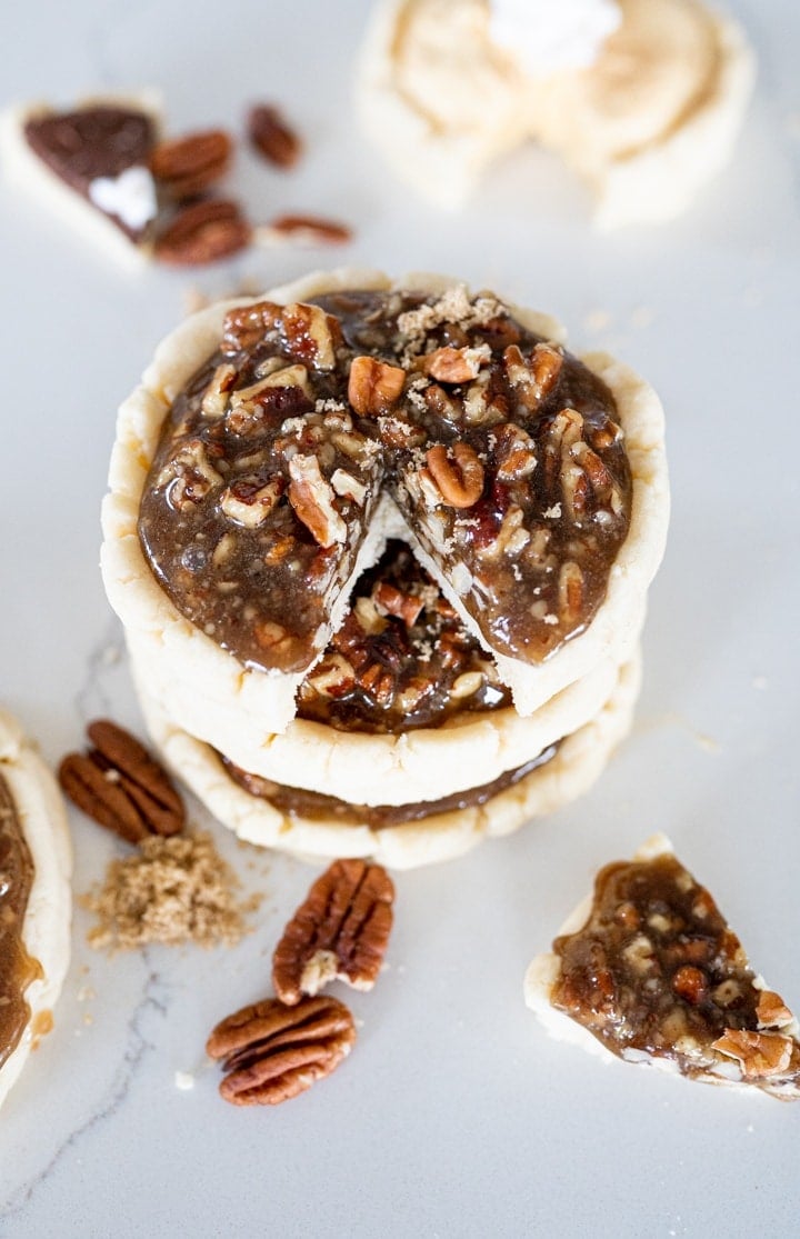 Crumbl pecan pie cookie, stacked on top of each other with a slice cut out of the top cookie
