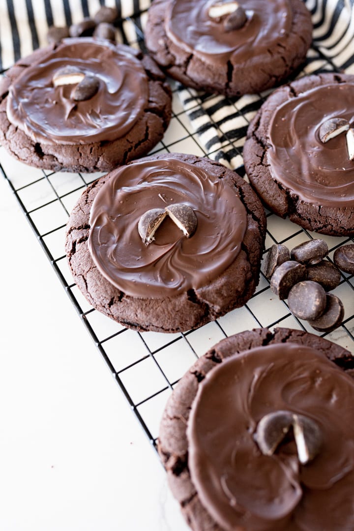 chocolate cookie with chocolate on top and a York peppermint patty on a black cookie cooling rack