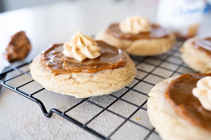 snickerdoodle cookie on a cookie cooling rack with dulce de leche on. top