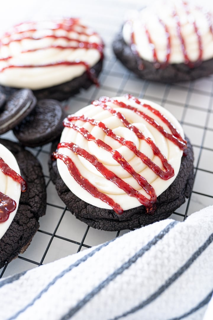 Oreo cookie base with cheesecake frosting and raspberry drizzle.