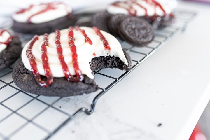 oreo raspberry cheesecake cookie with a bite taken out of it.