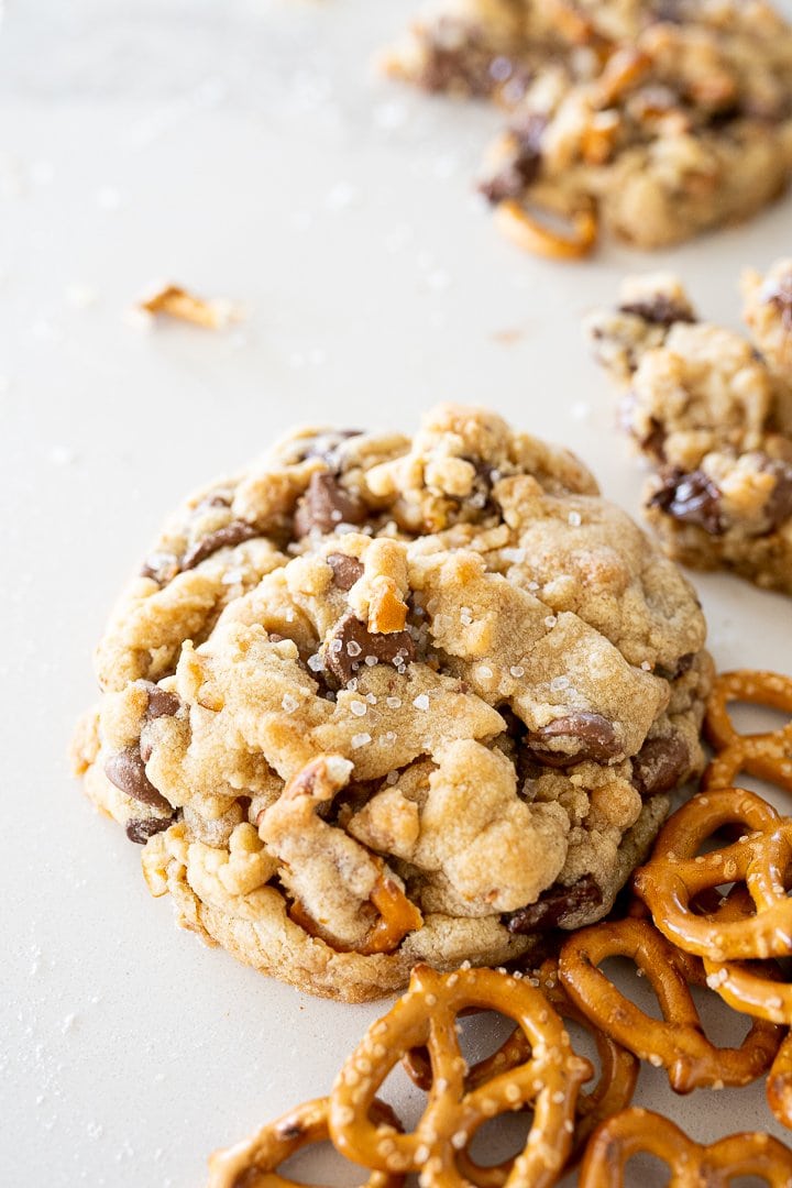 chocolate chip toffee cookies on the counter with pretzels by it. 