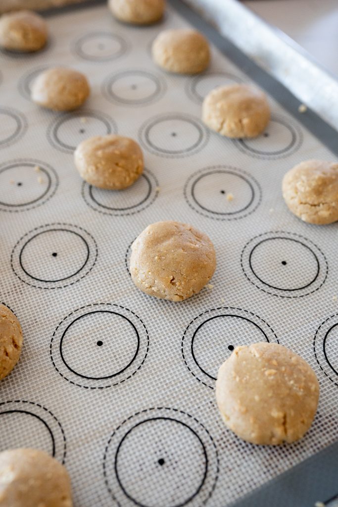 small cookie dough balls on a cookie sheet prior to baking
