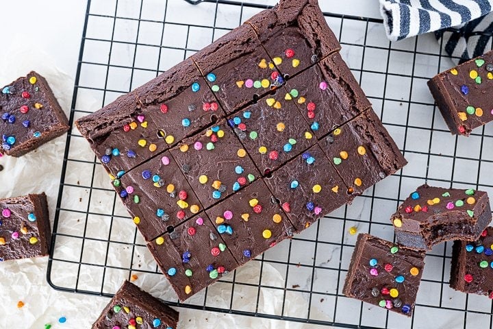 cut brownies with candy coated chocolate on top on a wire cooling rack