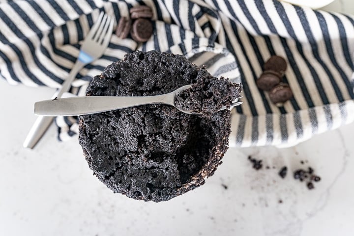 chocolate oreo mug cake with a portion taken out of it