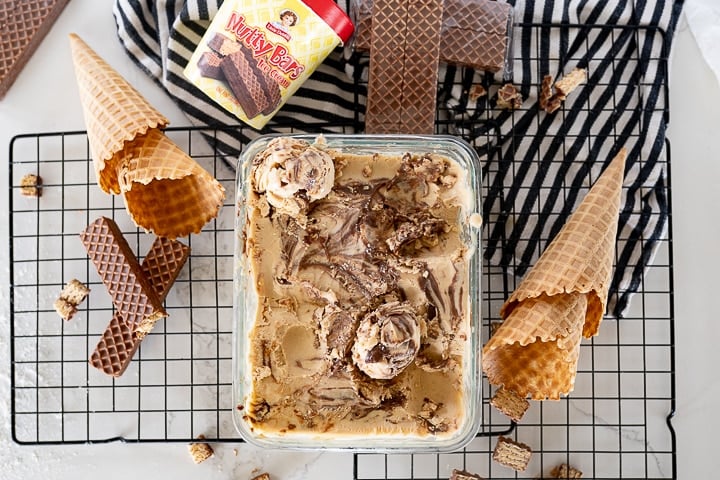 peanut butter ice cream with nutty buddies on the counter with some waffle cones