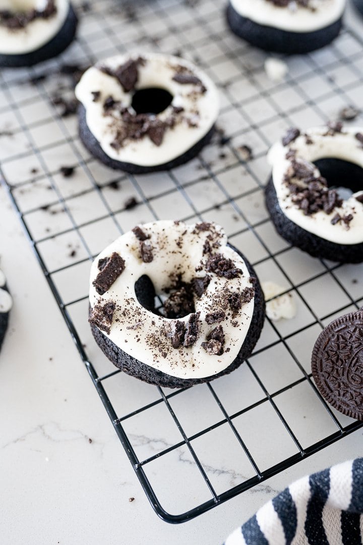 oreo donuts on a black cookie cooling rack 