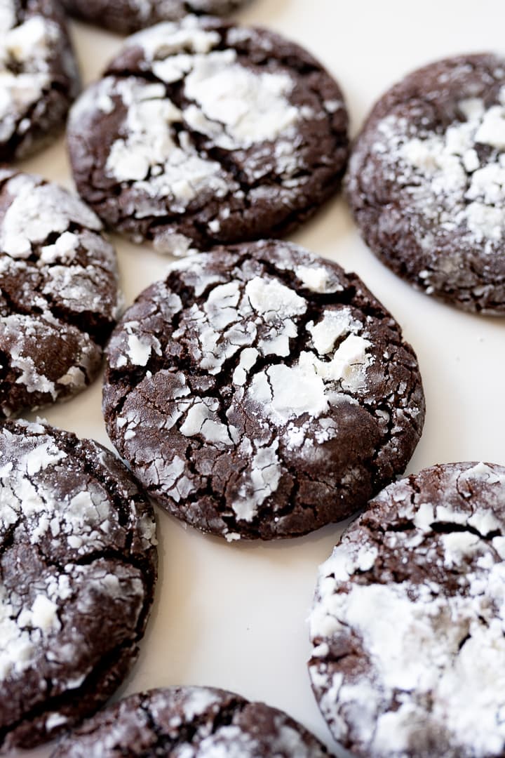 chocolate crinkle cookies on the counter with powdered sugar. 
