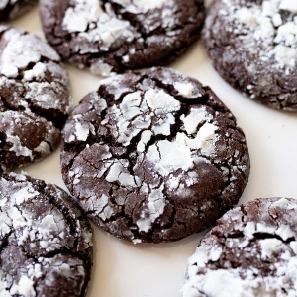 chocolate crinkle cookies on the counter, with powdered sugar on top.