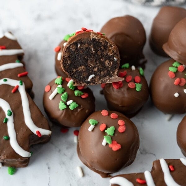 chocolate cake balls, covered in chocolate with Christmas sprinkle on top on the counter.