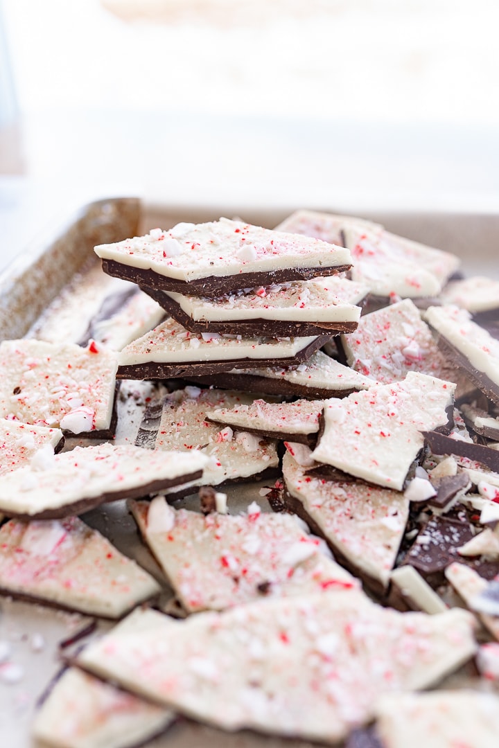 Large pile of peppermint bark stacked on a baking sheet on the counter.