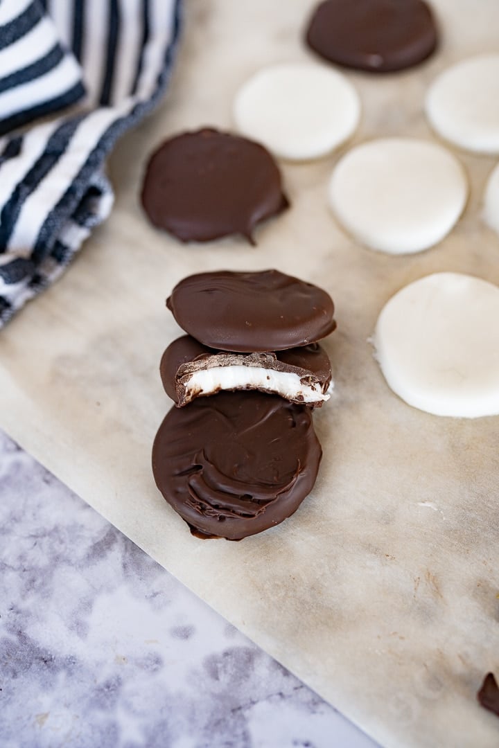 peppermint patties on parchment paper. One with a bite taken out of it. 