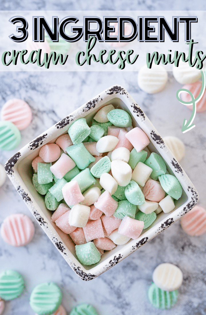 A bowl of red, white, and green cream cheese mints on the counter with black and green writing that reads "3 Ingredient Cream Cheese Mints."