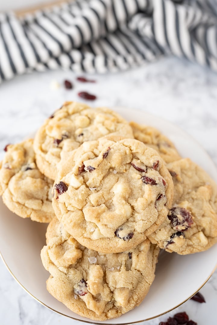 Several white chocolate cranberry cookies on a plate on the counter.